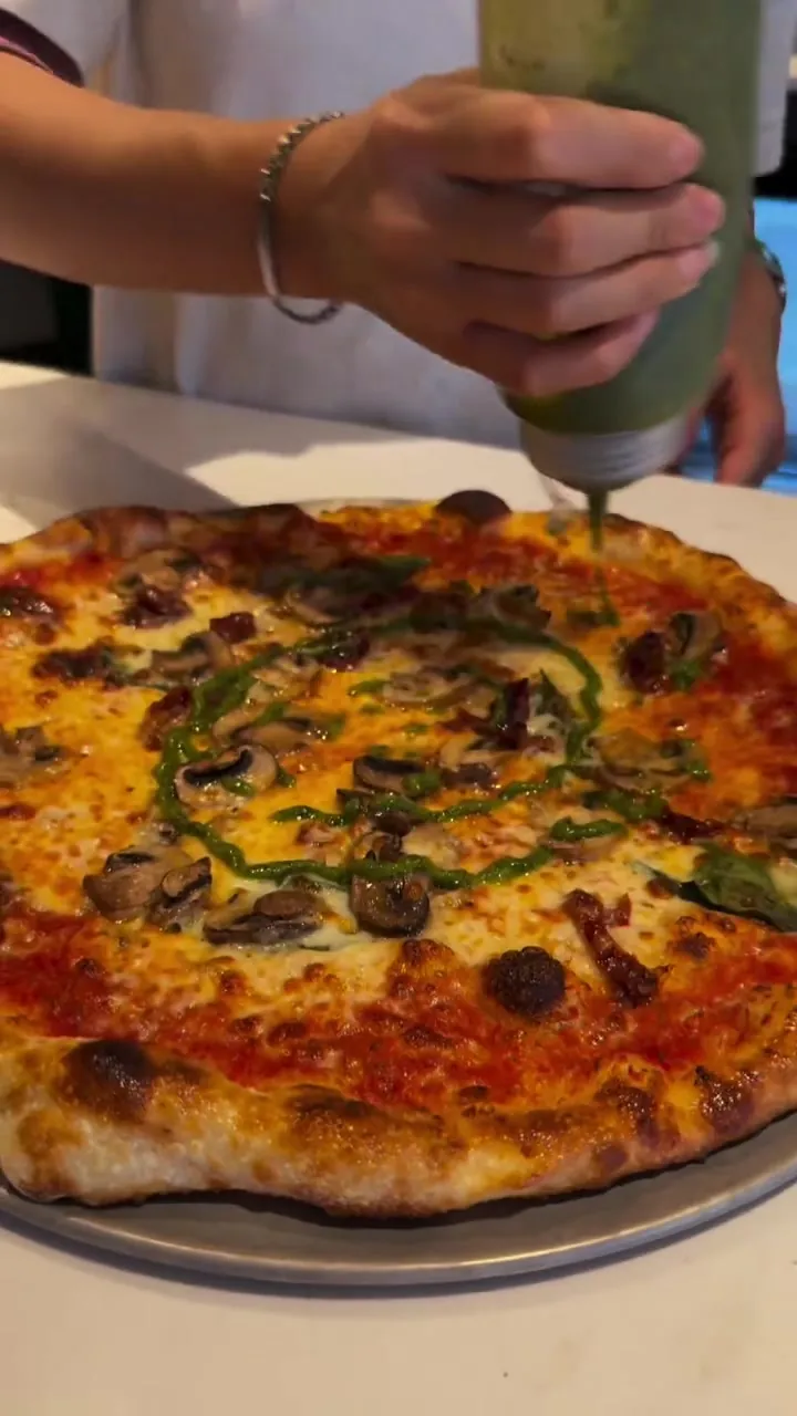 A pie finished with pesto straight out of the oven