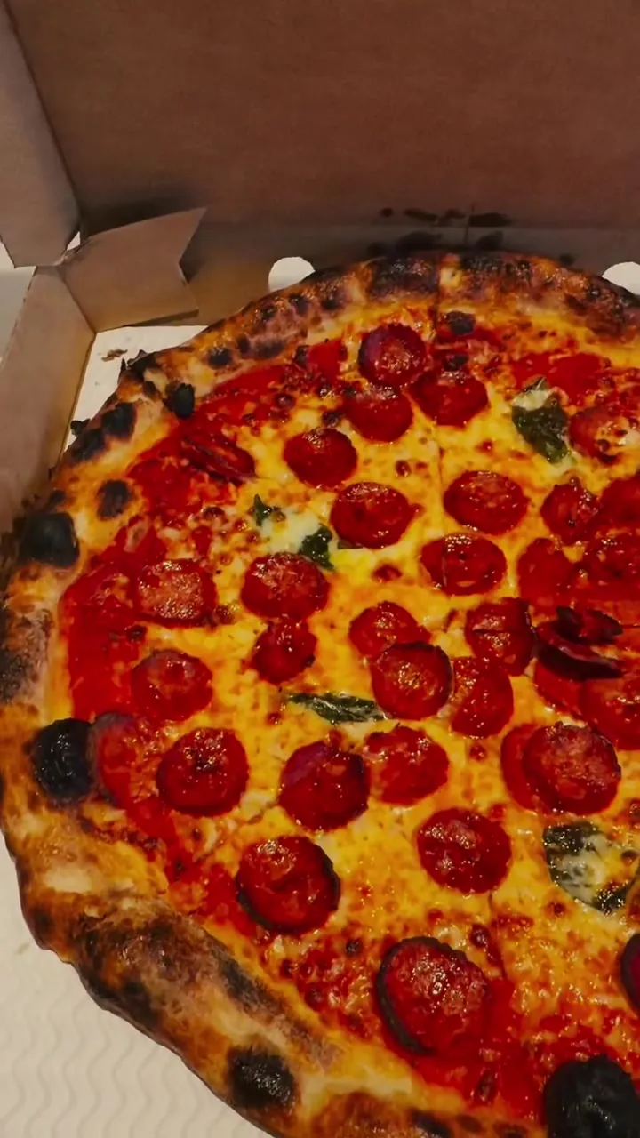 A pepperoni pie on a red gingham tablecloth