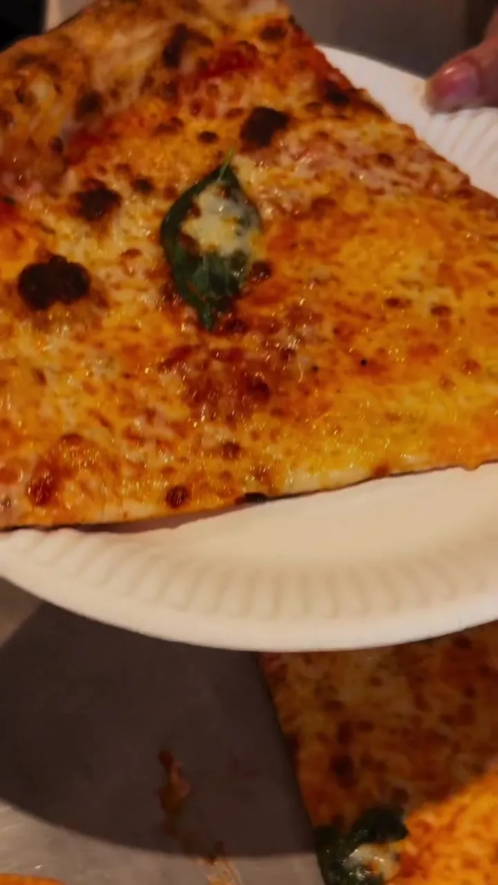 Slices of New York-style pizza on paper plates